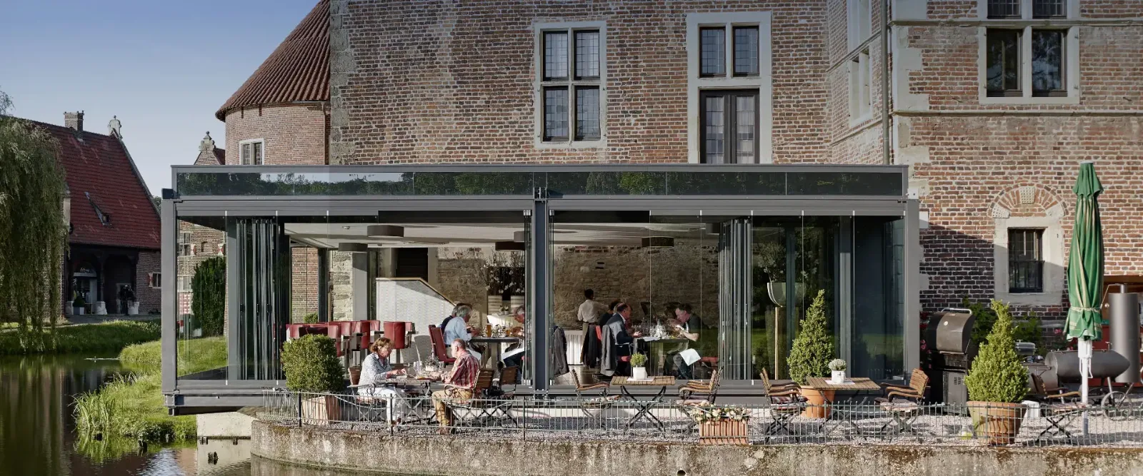 Szklana zabudowa tarasu restauracji przy zabytkowym budynku